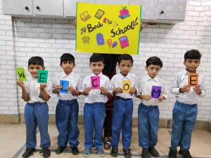 Smiling students with backpacks return to Baithak Schools.