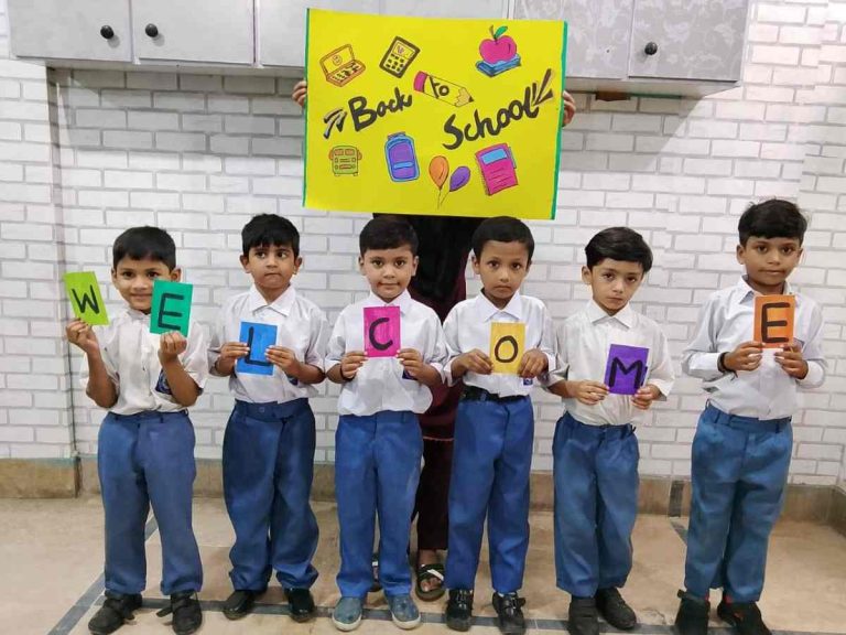 Smiling students with backpacks return to Baithak Schools.