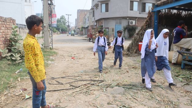 Child carrying a school bag on the way to school in a community setting